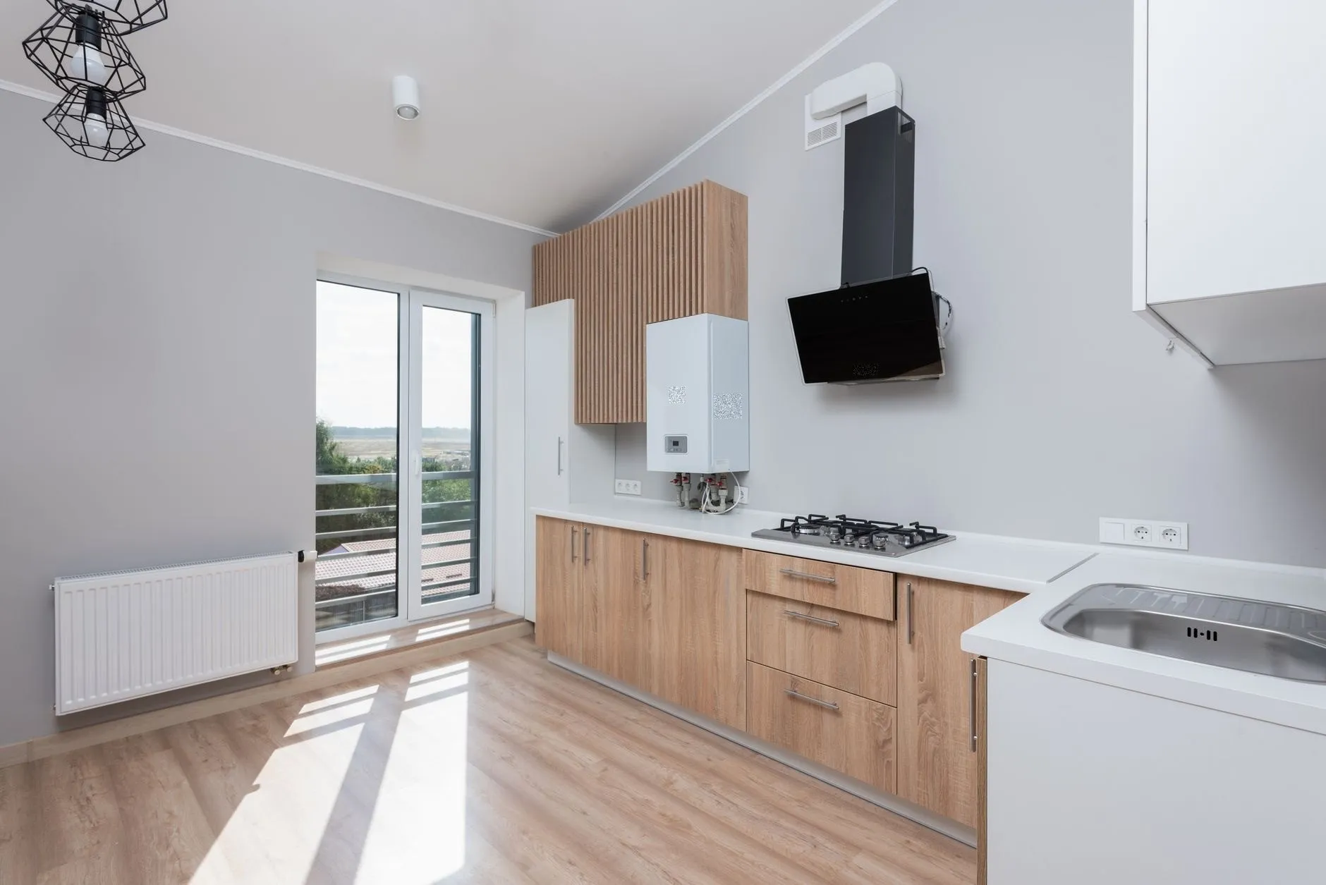 Kitchen with oak units and a glazed door to a balcony