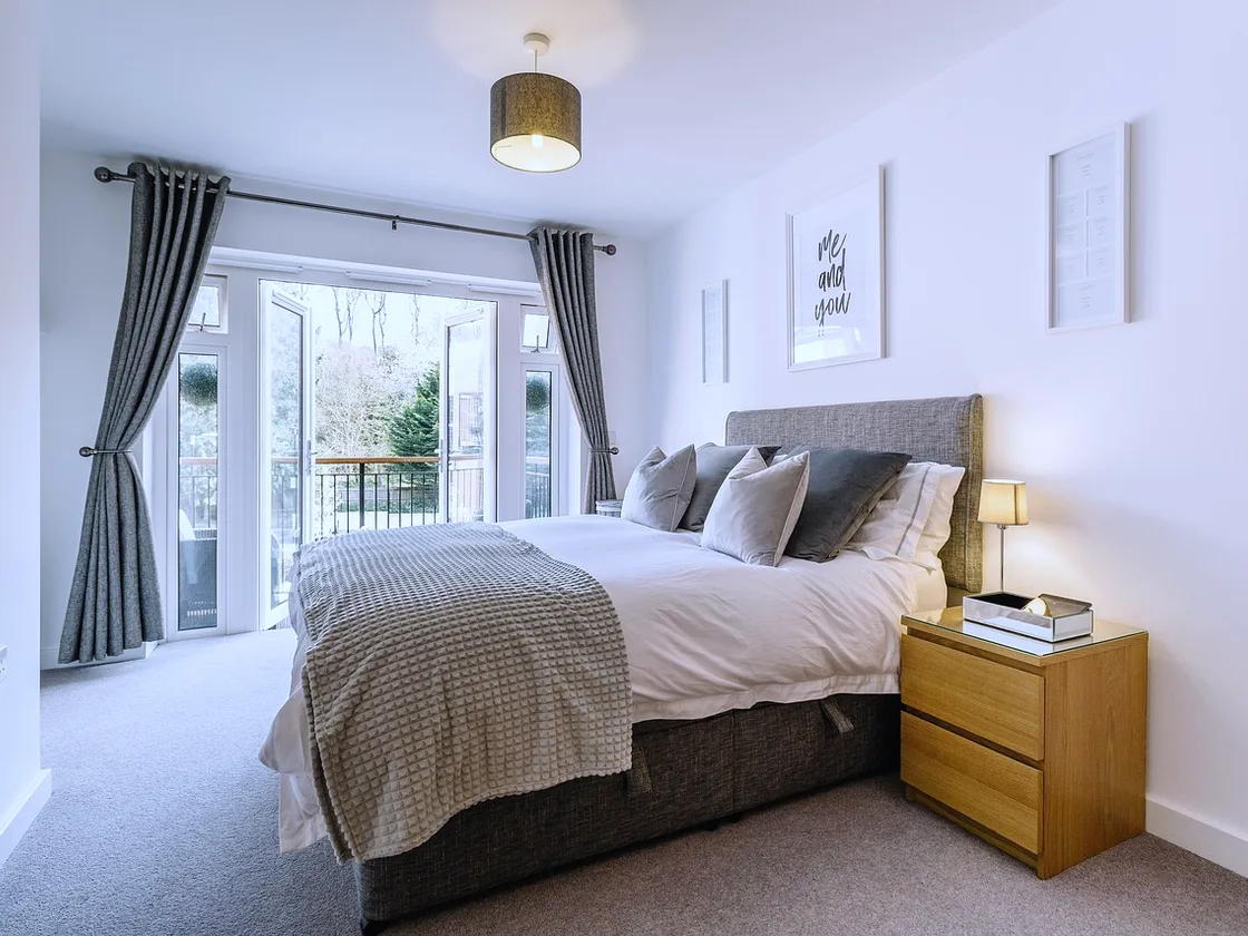 Principal bedroom at Ashcombe Hill House with doors onto a west balcony